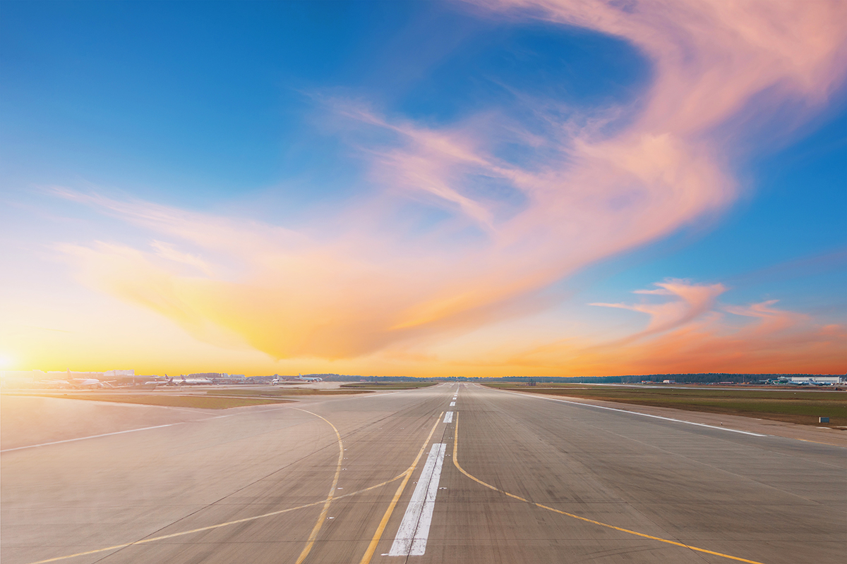 Empty runway at evening airport during sunset